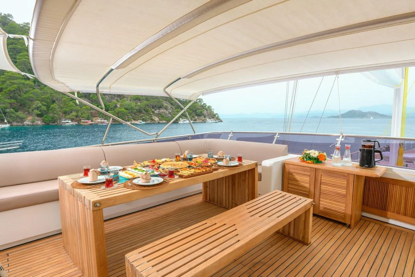 The alfresco dining area offers a serene setting with a beautifully set table and stunning views of the surrounding waters. aboard BELGIN SULTAN Yacht for Sale