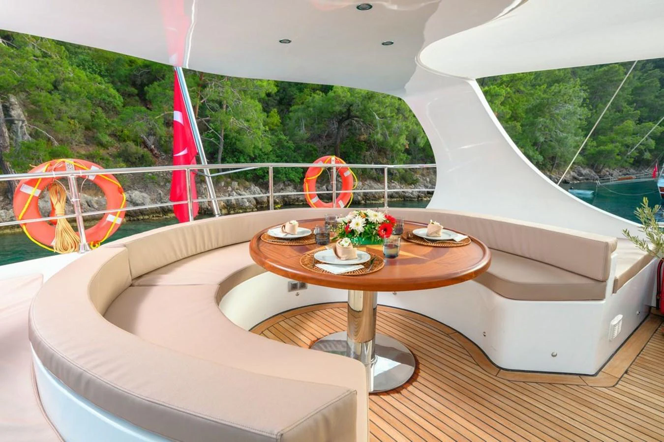 The aft deck features a stylish curved seating area with a polished wooden table, perfect for alfresco dining. aboard BELGIN SULTAN Yacht for Sale
