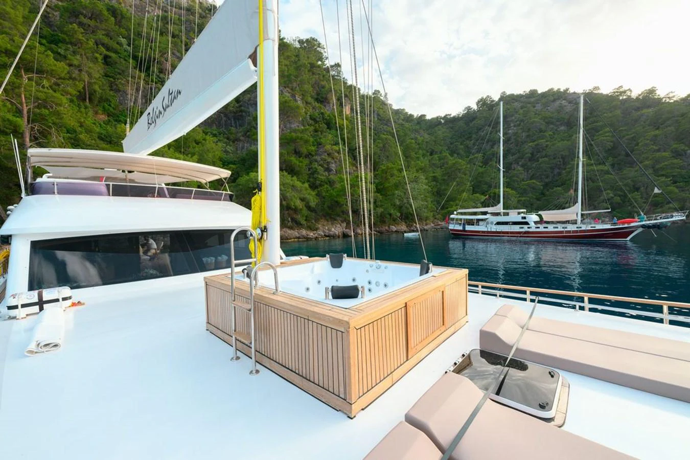 The yacht's deck features a luxurious hot tub with scenic views of the surrounding waters and lush greenery. aboard BELGIN SULTAN Yacht for Sale