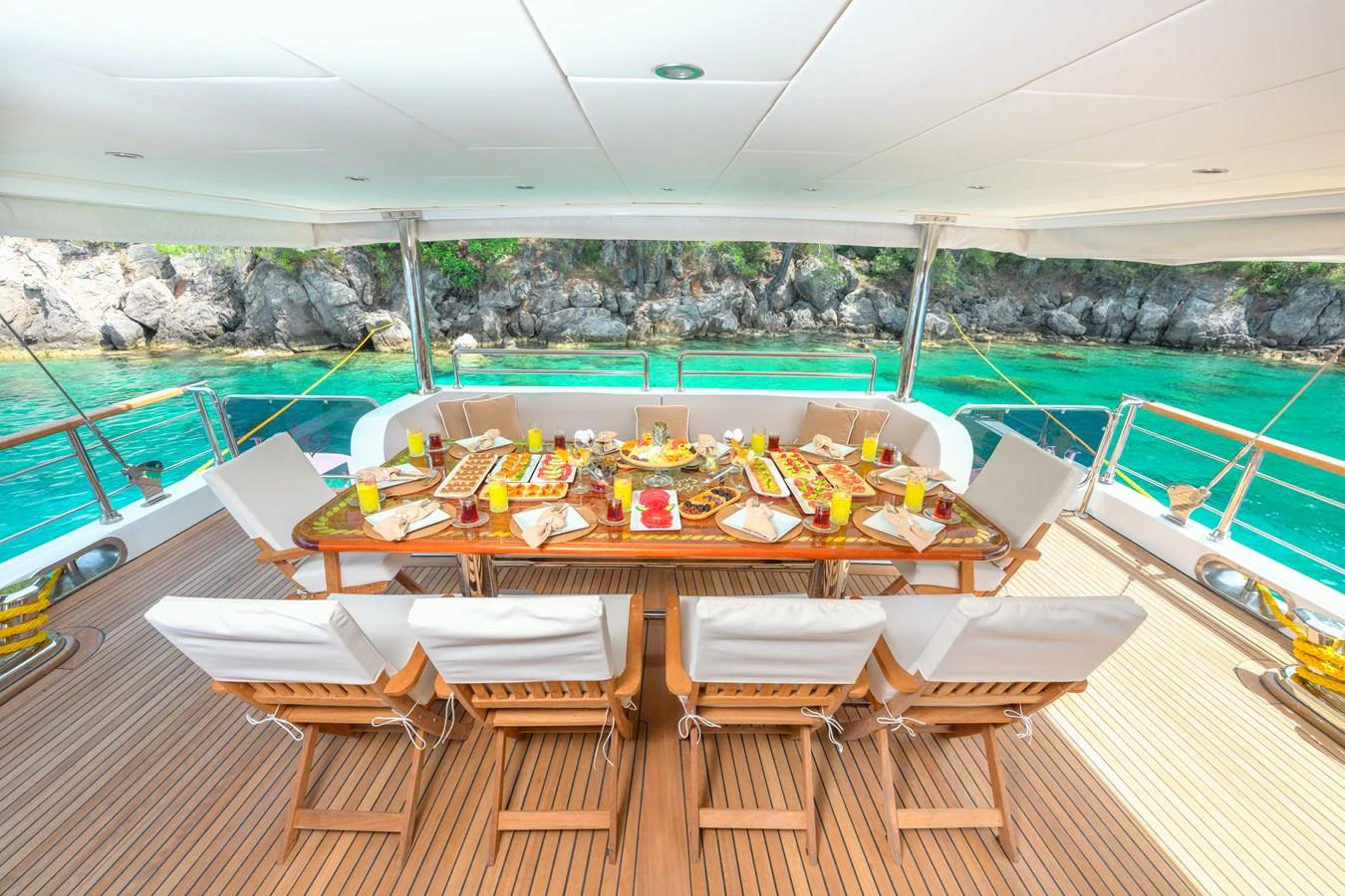 The aft deck features an elegant dining area with a stunning view of the turquoise waters. aboard BELGIN SULTAN Yacht for Sale