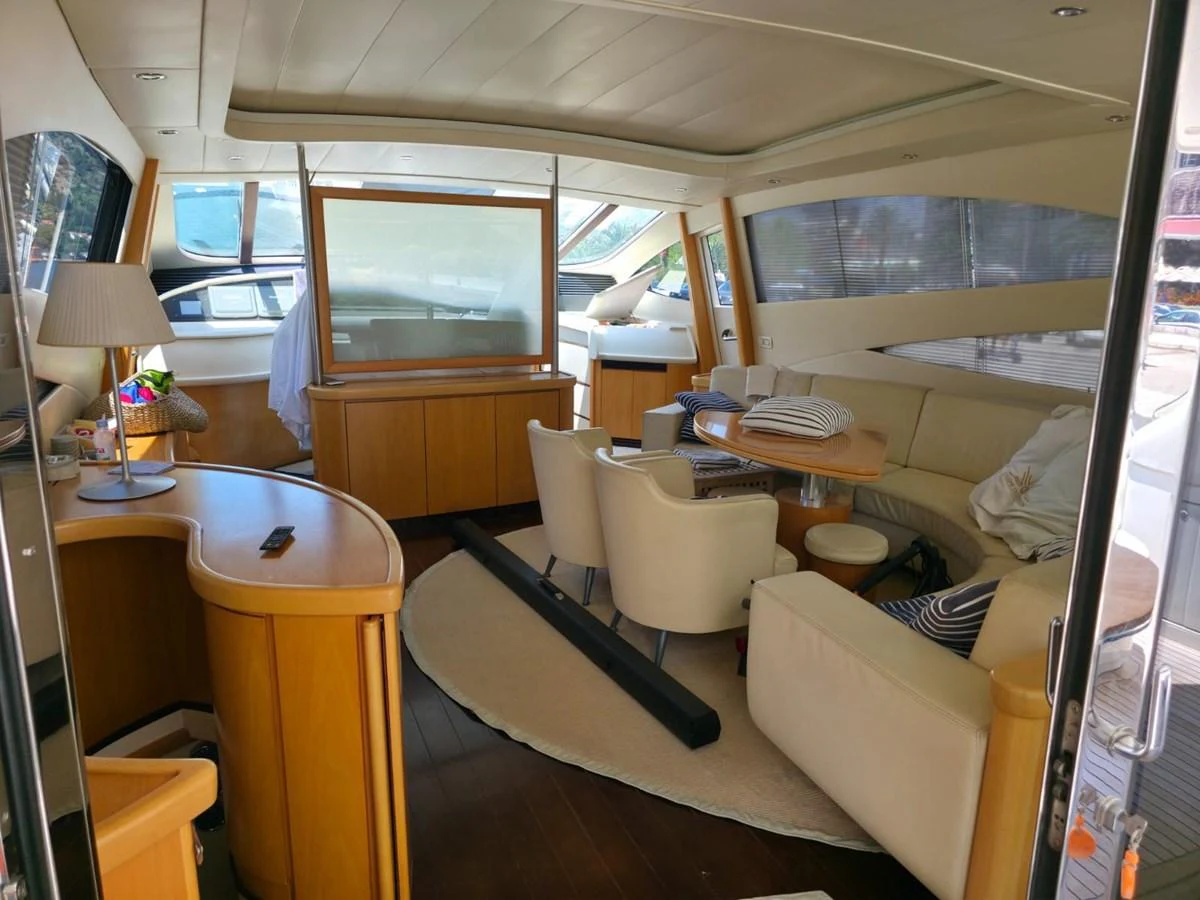 The yacht's interior features a spacious and elegantly designed living area with ample seating and natural light. aboard EVASIONE Yacht for Sale