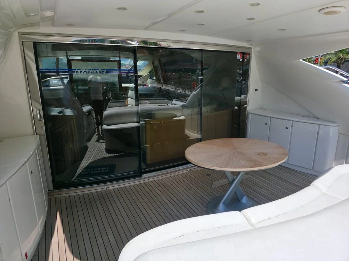 The aft deck features a cozy seating area with a round table, perfect for relaxing or dining. aboard EVASIONE Yacht for Sale