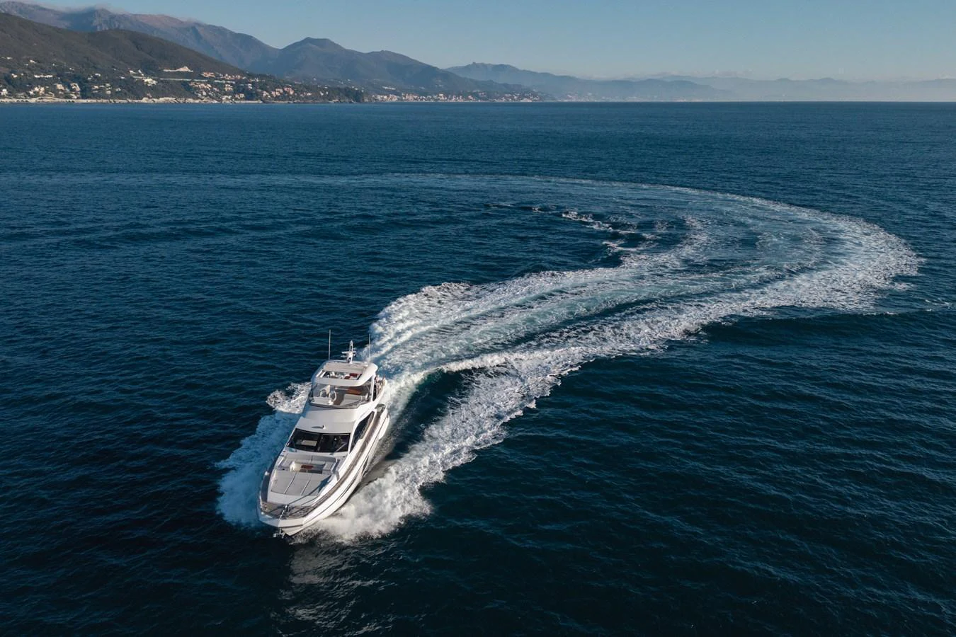 A sleek yacht glides through the open sea, leaving a graceful wake behind. aboard HELSIE SI Yacht for Sale