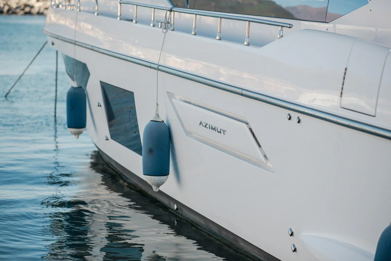 A close-up view of the yacht's sleek hull with fenders hanging over the side. aboard HELSIE SI Yacht for Sale