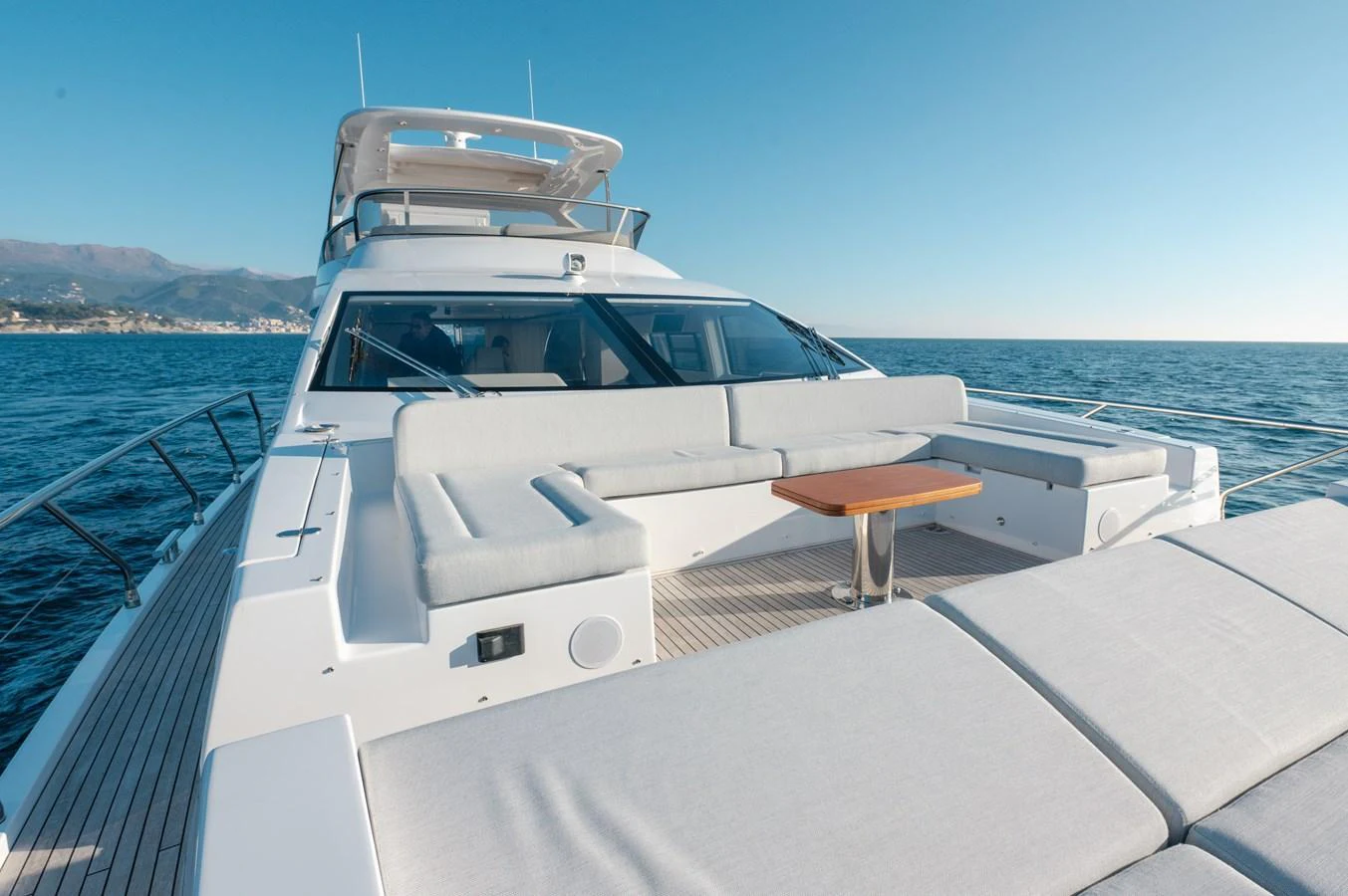 The foredeck of this yacht features spacious sun pads and a comfortable seating area with a table, perfect for relaxation and socializing. aboard HELSIE SI Yacht for Sale