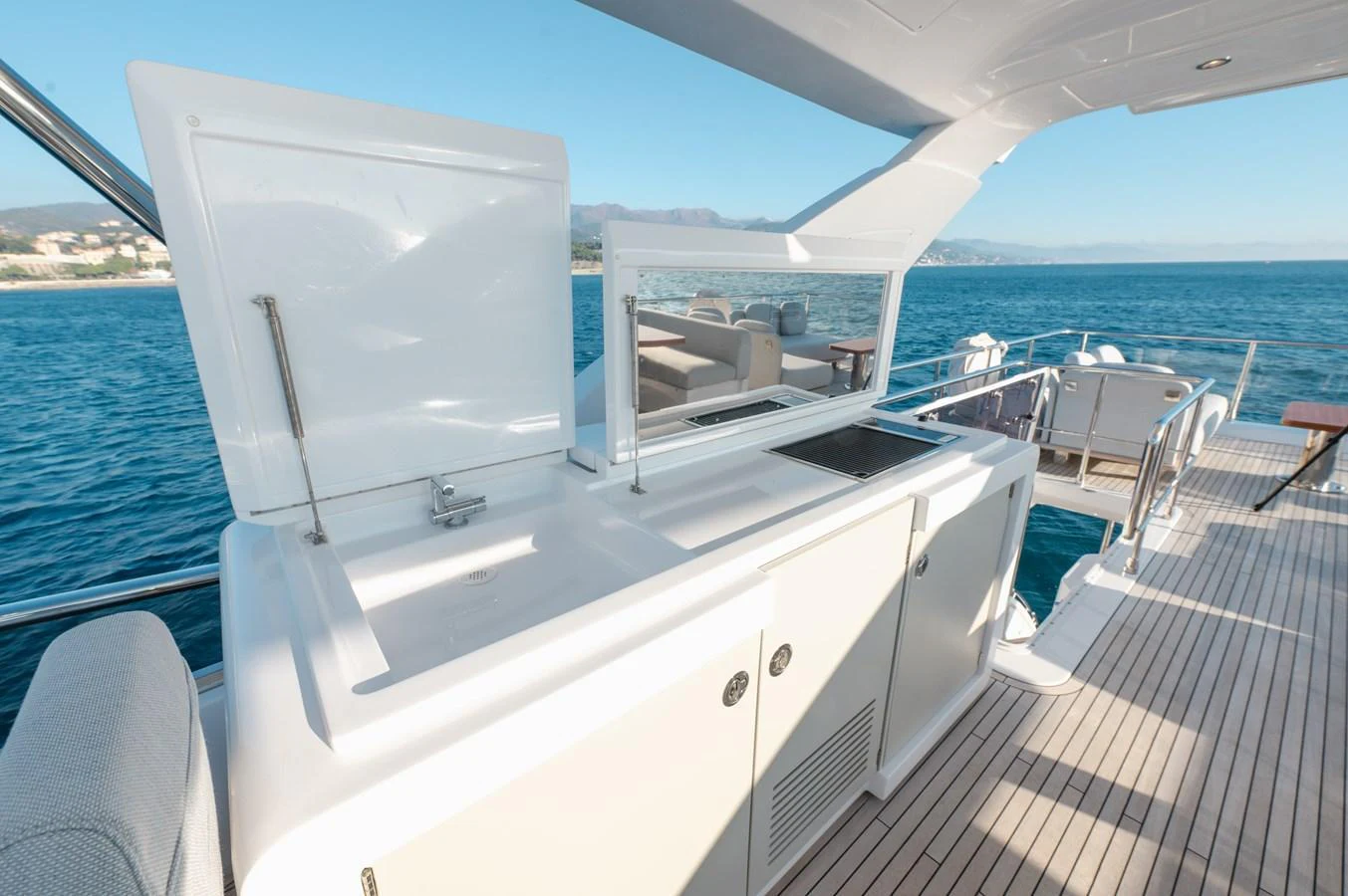 The flybridge features a sleek outdoor kitchenette with stunning ocean views. aboard HELSIE SI Yacht for Sale