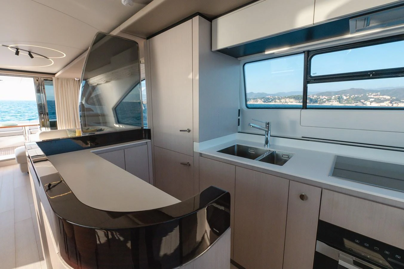The modern galley features sleek cabinetry and high-end appliances with a view of the sea. aboard HELSIE SI Yacht for Sale