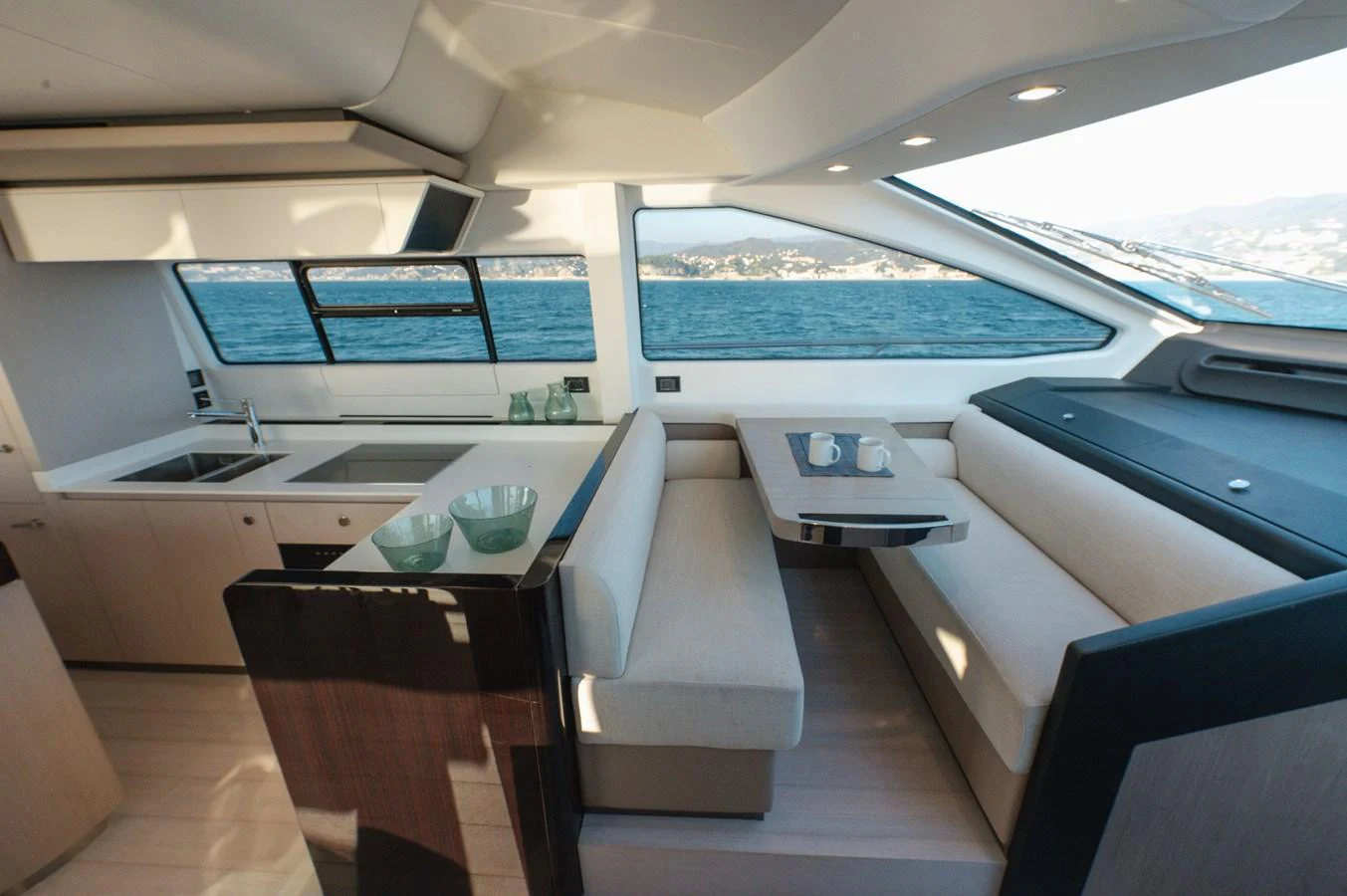The yacht's saloon features a modern dining area with panoramic windows offering stunning sea views. aboard HELSIE SI Yacht for Sale