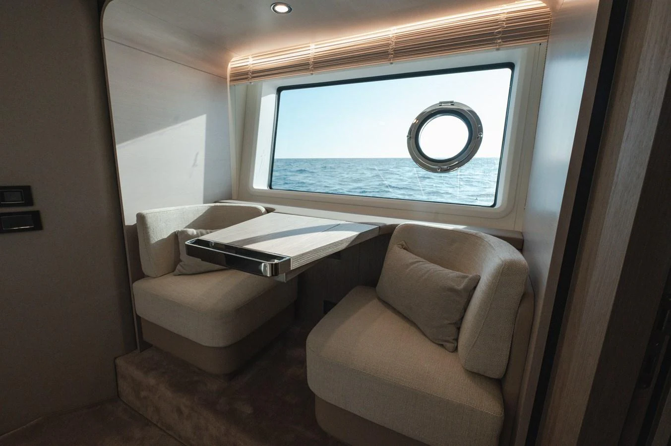 A cozy seating area with a table and a large window offering a view of the sea. aboard HELSIE SI Yacht for Sale