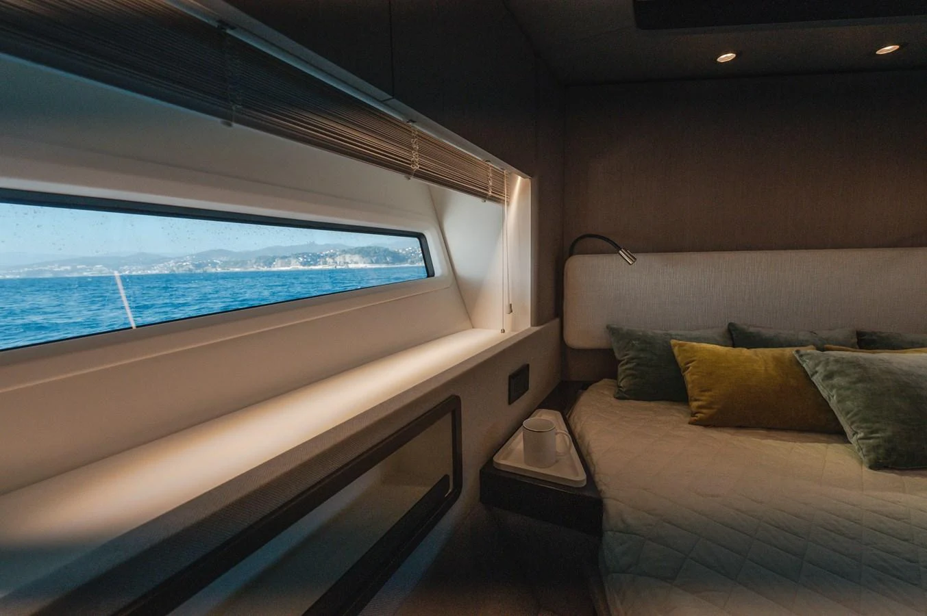 A cozy stateroom with a large window offering a scenic view of the sea. aboard HELSIE SI Yacht for Sale