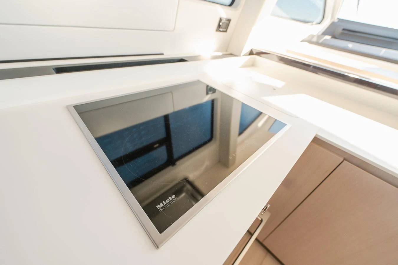 The modern galley features a sleek induction cooktop and ample natural light. aboard HELSIE SI Yacht for Sale