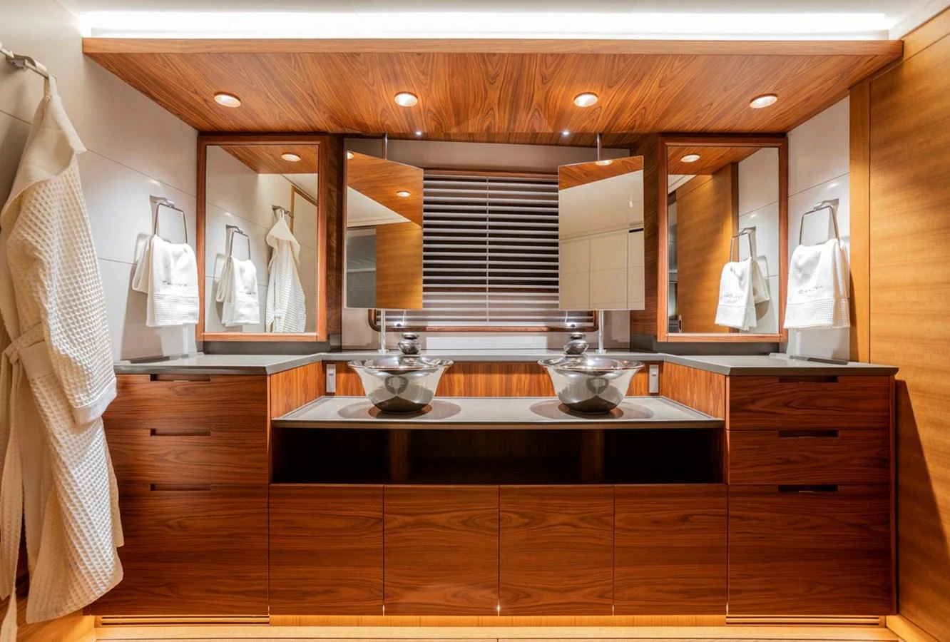 The yacht's bathroom features a luxurious double vanity with modern fixtures and rich wood finishes. aboard CANOVA Yacht for Sale