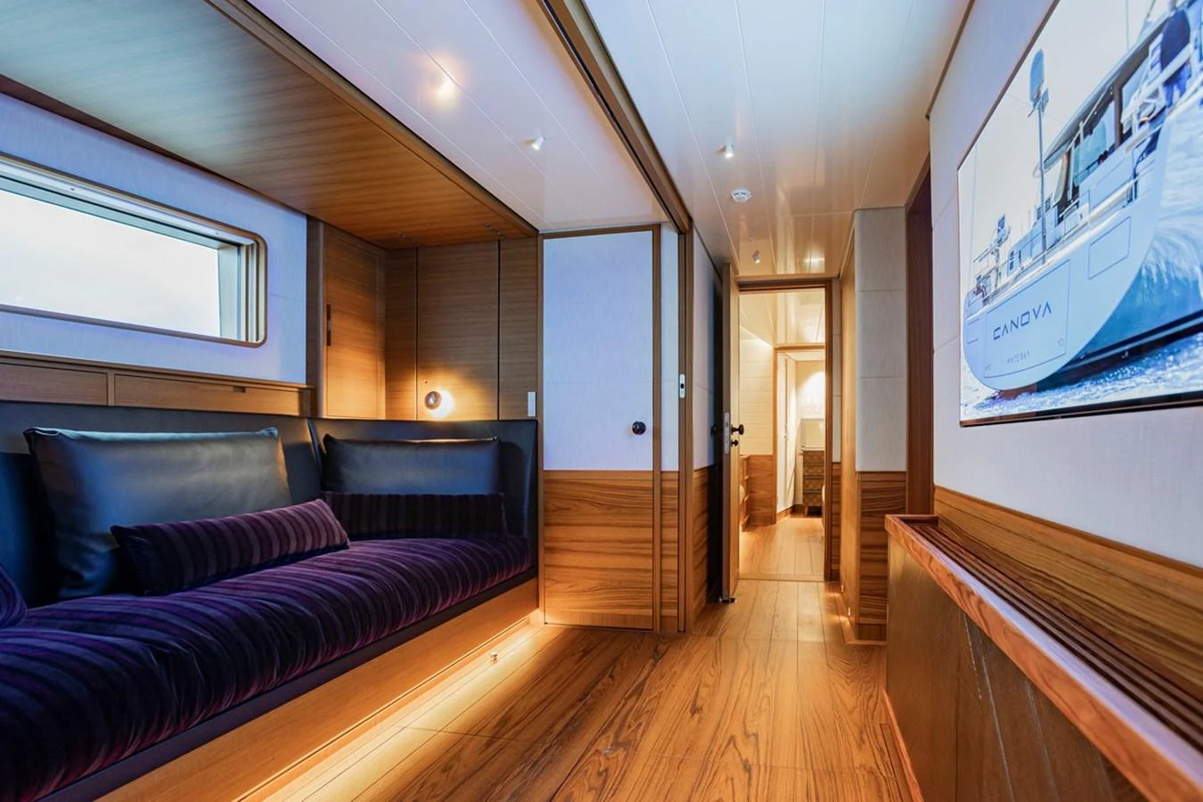 A luxurious yacht hallway featuring elegant wood paneling and ambient lighting. aboard CANOVA Yacht for Sale