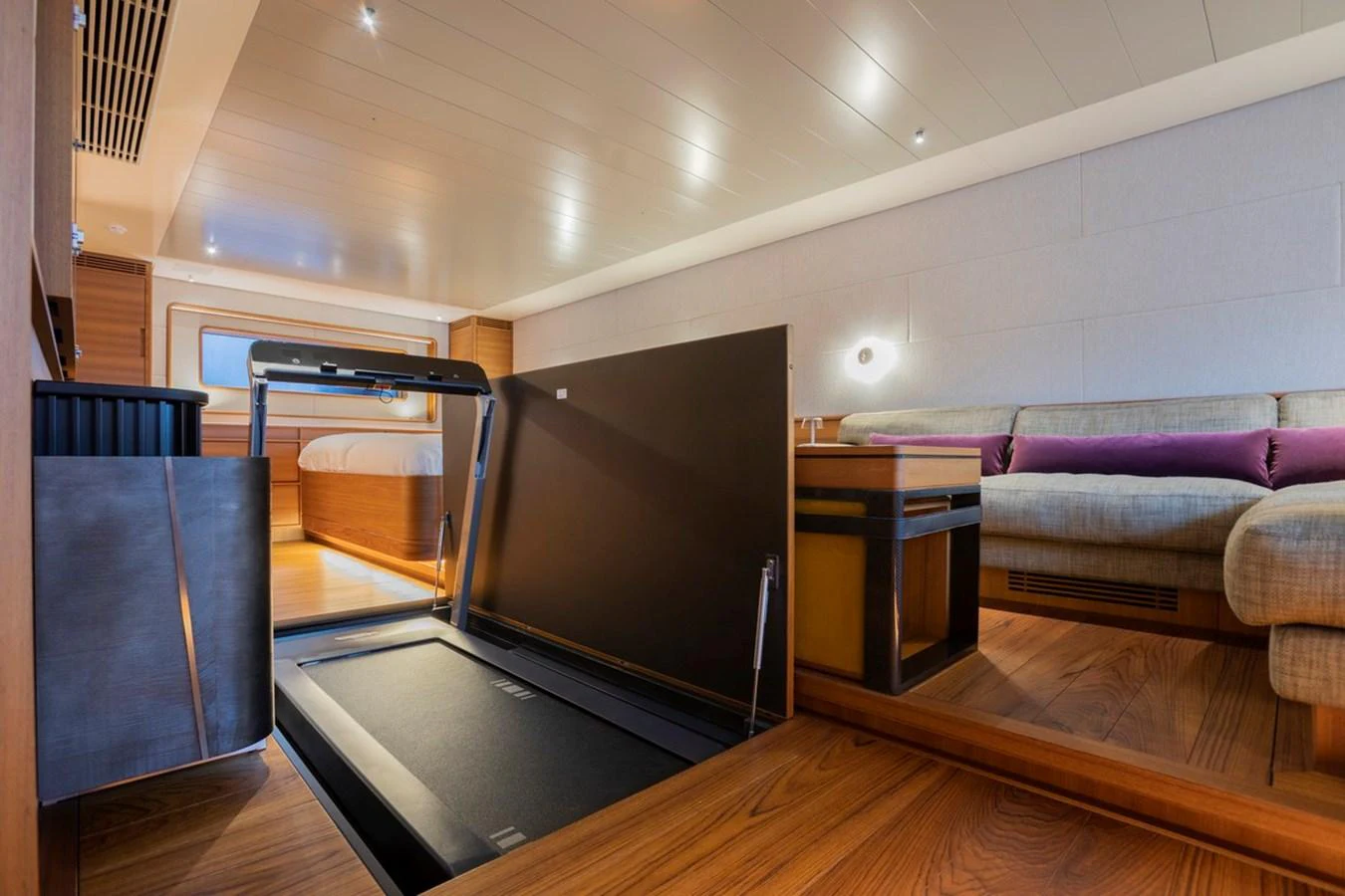 A luxurious stateroom featuring a hidden treadmill and comfortable seating area. aboard CANOVA Yacht for Sale