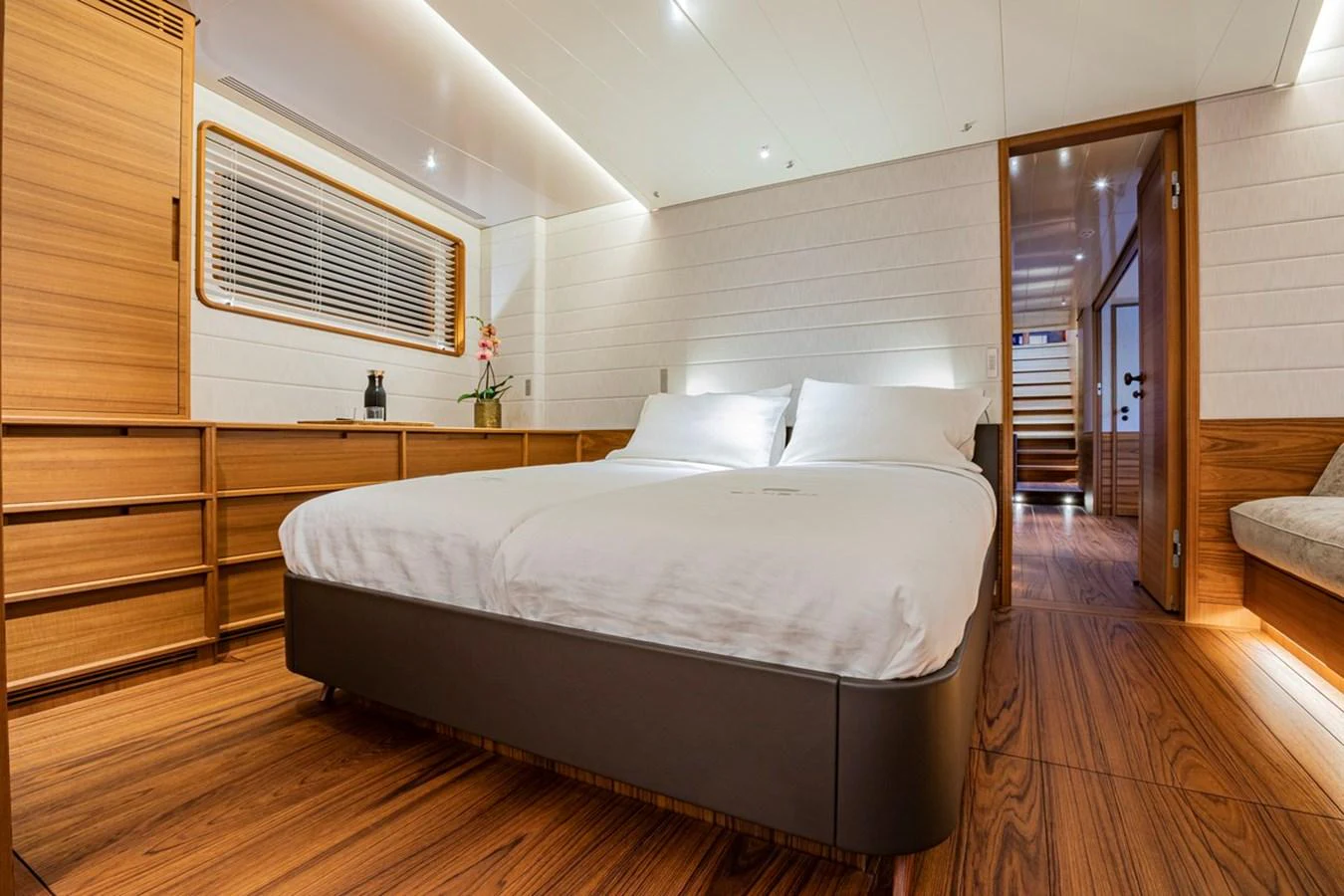 A luxurious stateroom featuring a comfortable bed and elegant wooden furnishings. aboard CANOVA Yacht for Sale