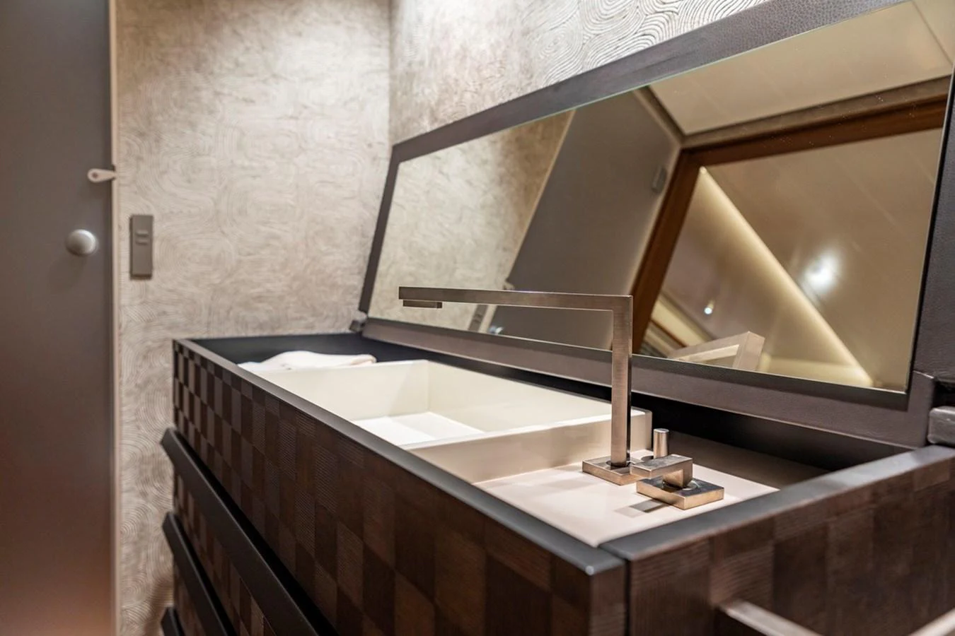 A modern yacht bathroom with a sleek sink and large mirror. aboard CANOVA Yacht for Sale
