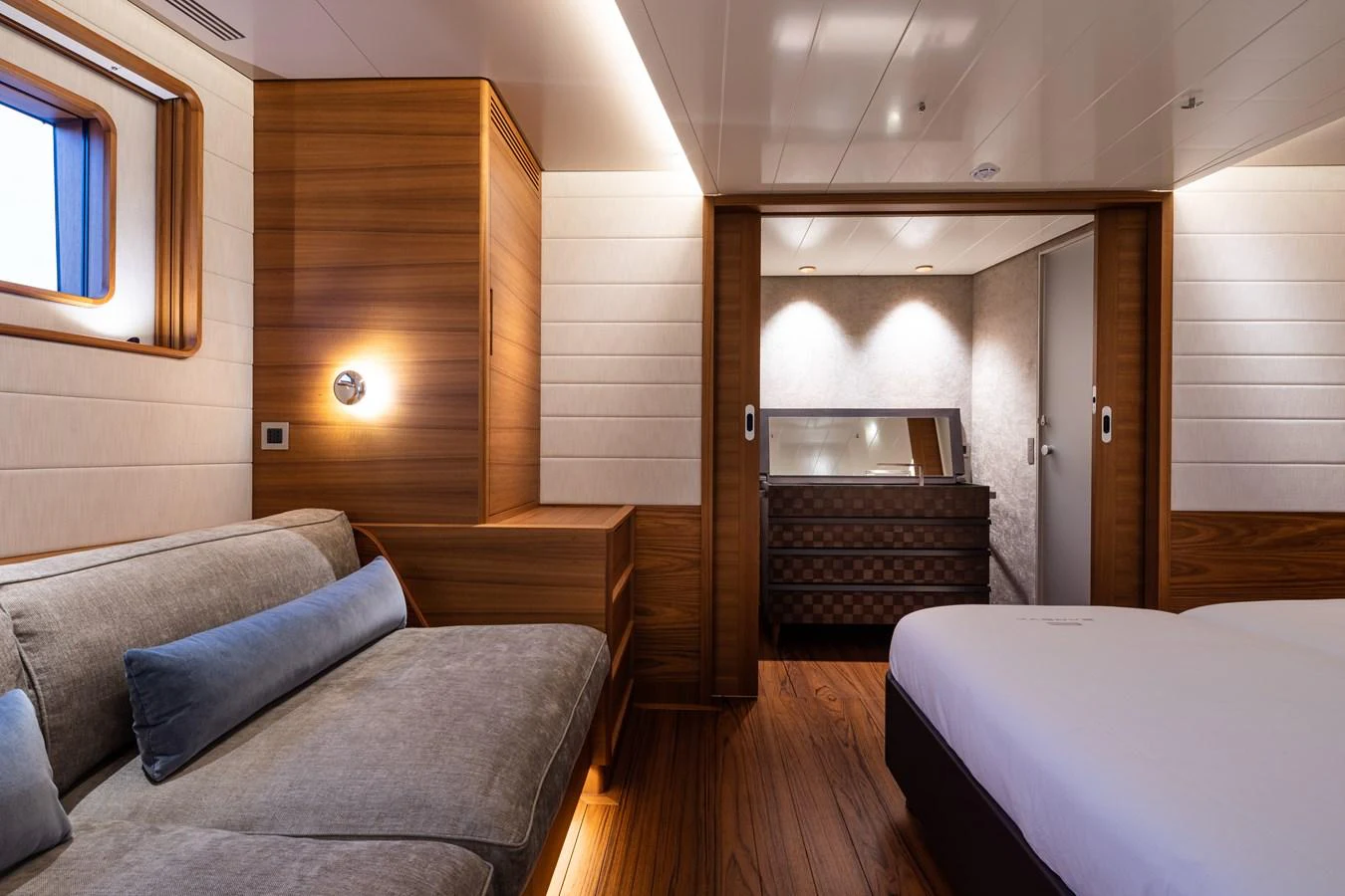 The stateroom features elegant wood paneling, a comfortable sofa, and a luxurious bed. aboard CANOVA Yacht for Sale