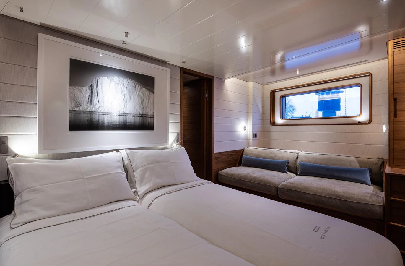 The guest stateroom features a cozy double bed, a comfortable sofa, and a large window for natural light. aboard CANOVA Yacht for Sale