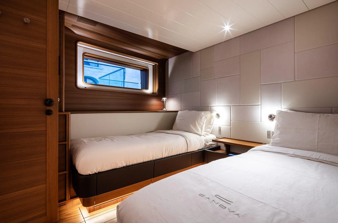 The guest stateroom features twin beds with a modern, cozy design and ample natural light. aboard CANOVA Yacht for Sale