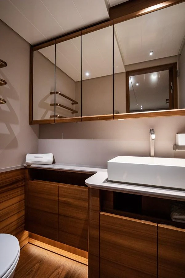 The yacht's bathroom features sleek wooden cabinetry and modern fixtures. aboard CANOVA Yacht for Sale