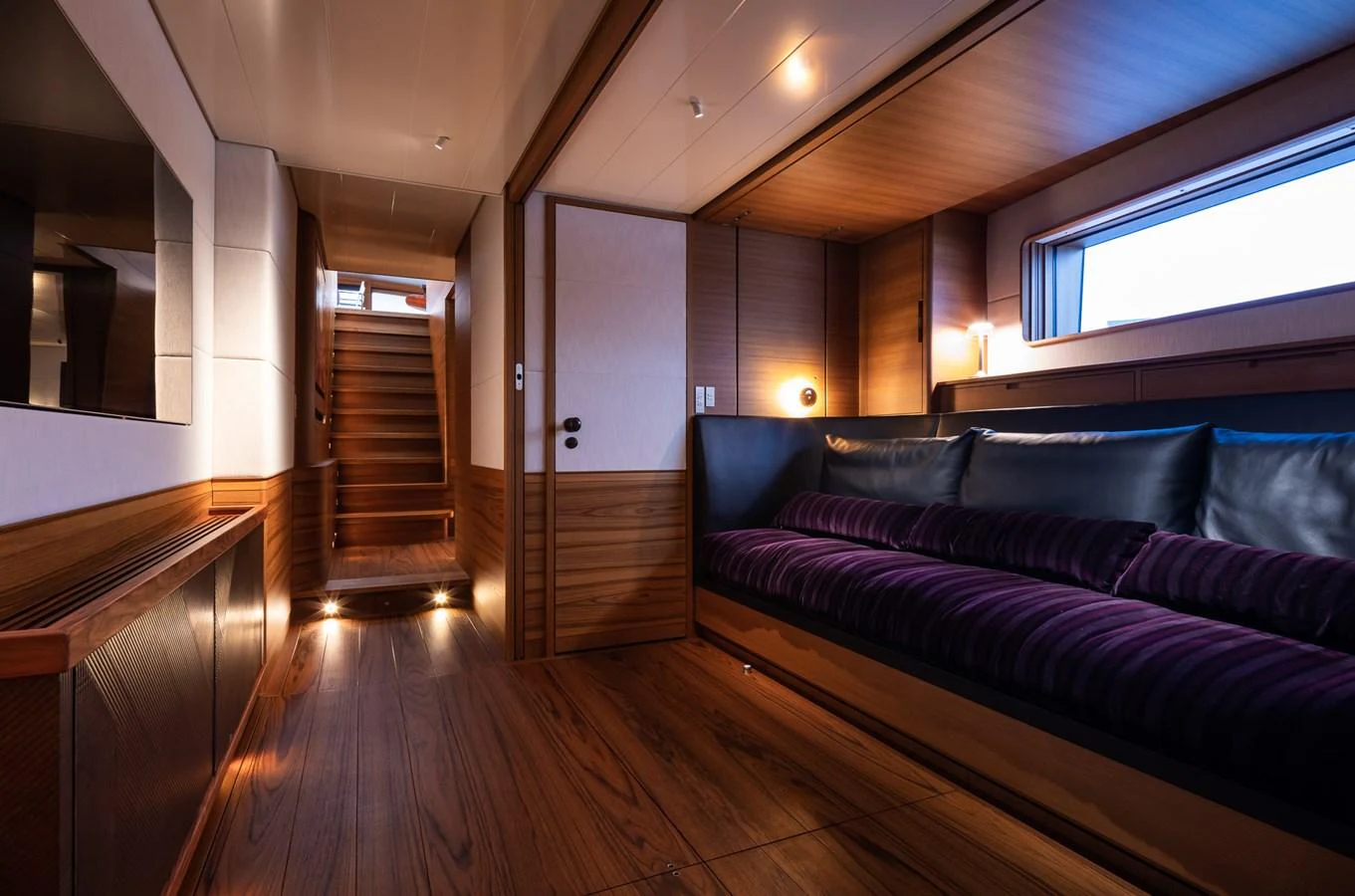 The yacht's interior features a cozy lounge area with warm wood finishes and ambient lighting. aboard CANOVA Yacht for Sale