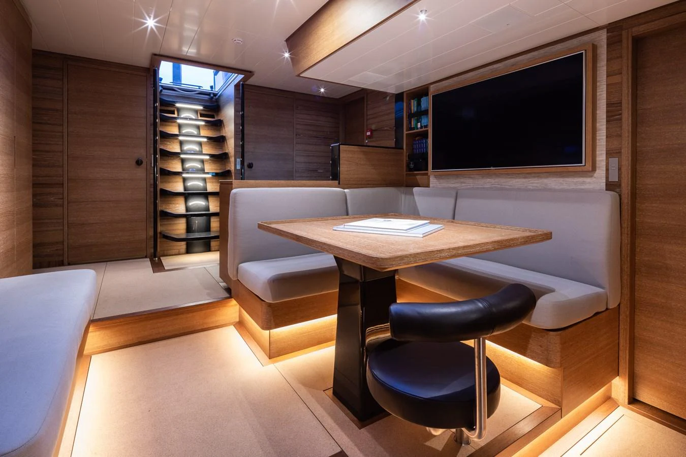 The yacht's salon features a cozy seating area with a modern table and ambient lighting. aboard CANOVA Yacht for Sale