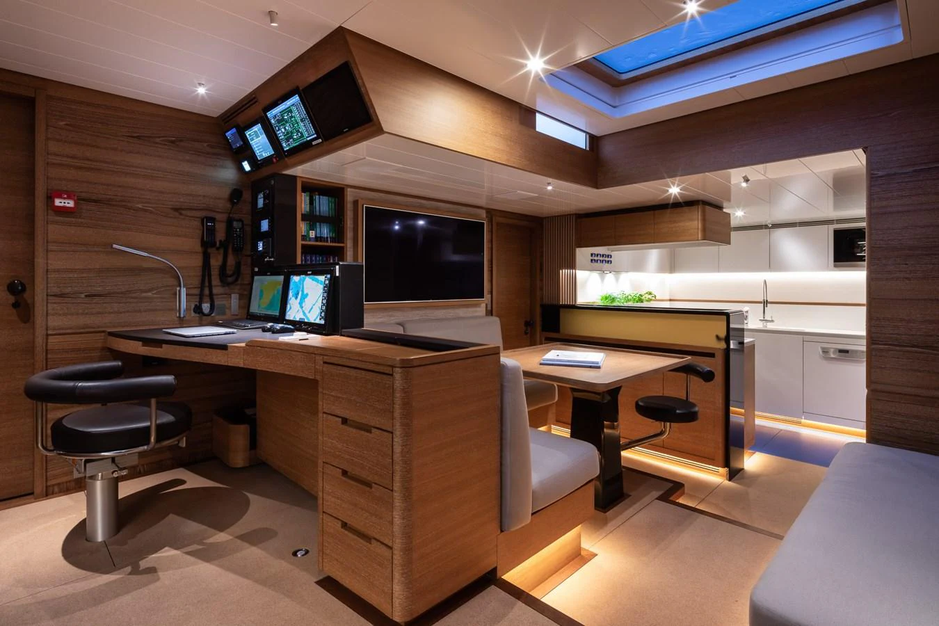 The yacht's navigation station features modern equipment and a sleek, wood-paneled design. aboard CANOVA Yacht for Sale
