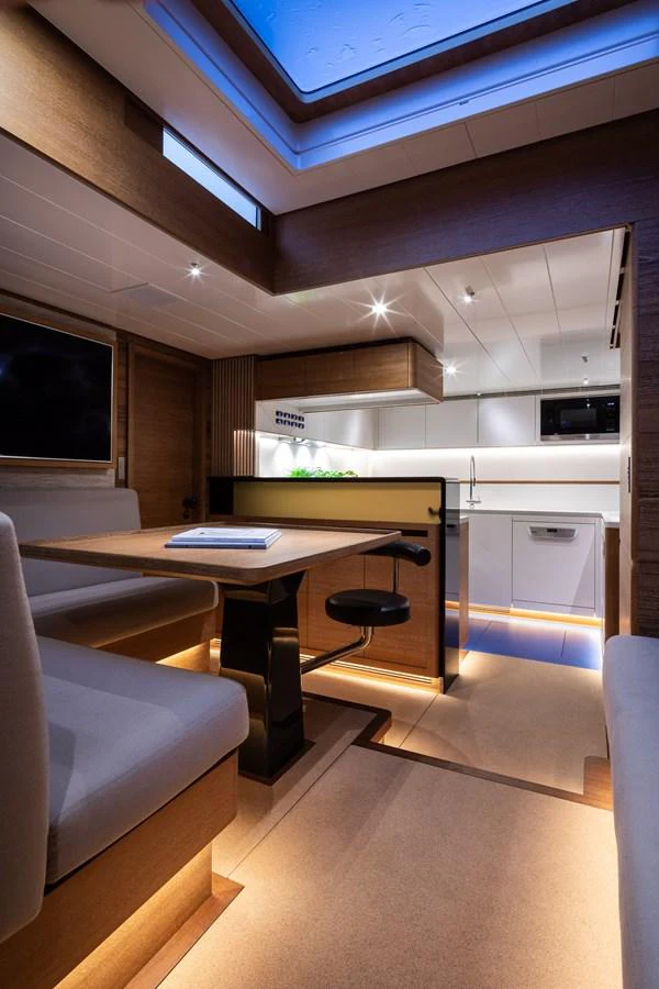 The yacht's galley features modern amenities and a cozy dining area with ambient lighting. aboard CANOVA Yacht for Sale