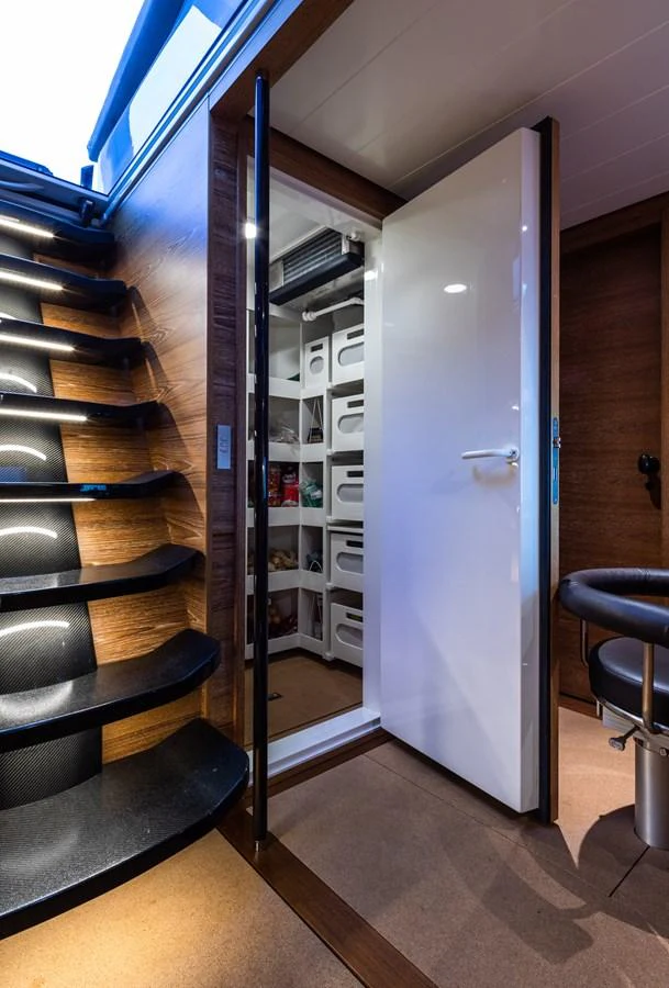 A sleek interior storage area with organized shelving and a modern staircase. aboard CANOVA Yacht for Sale