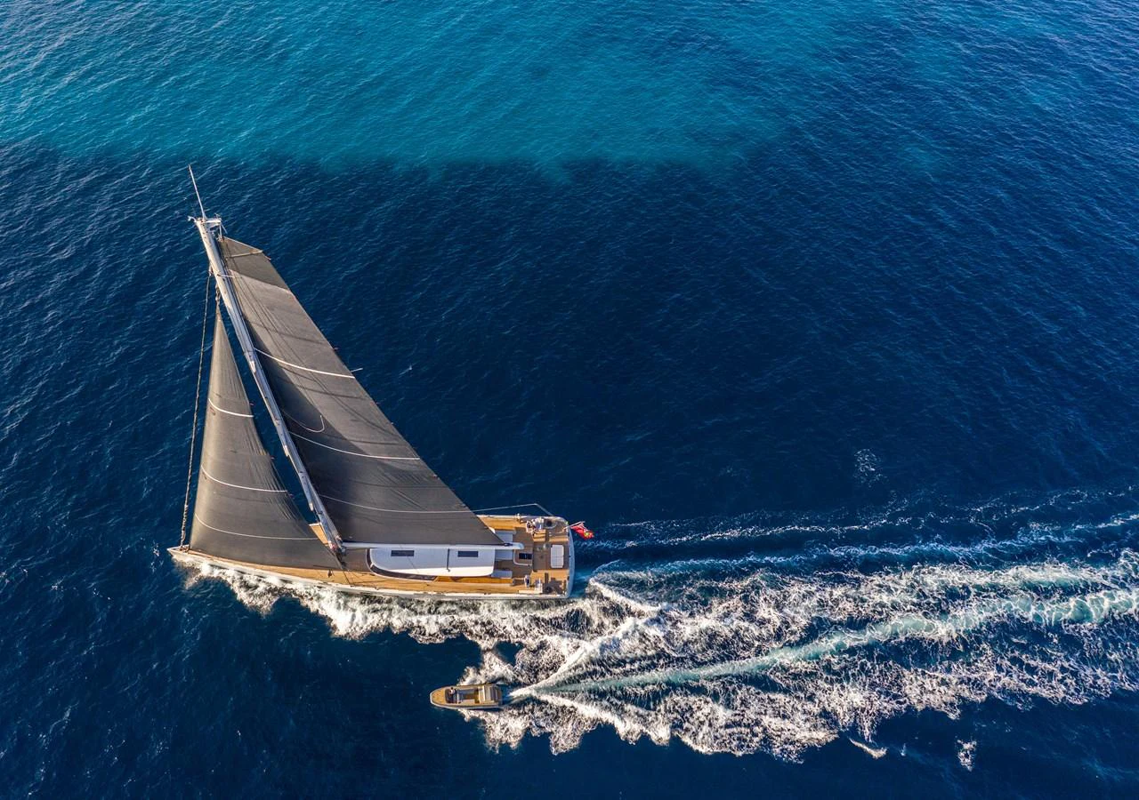 A sleek sailing yacht glides through the deep blue sea, showcasing its elegant design and impressive sails. aboard CANOVA Yacht for Sale