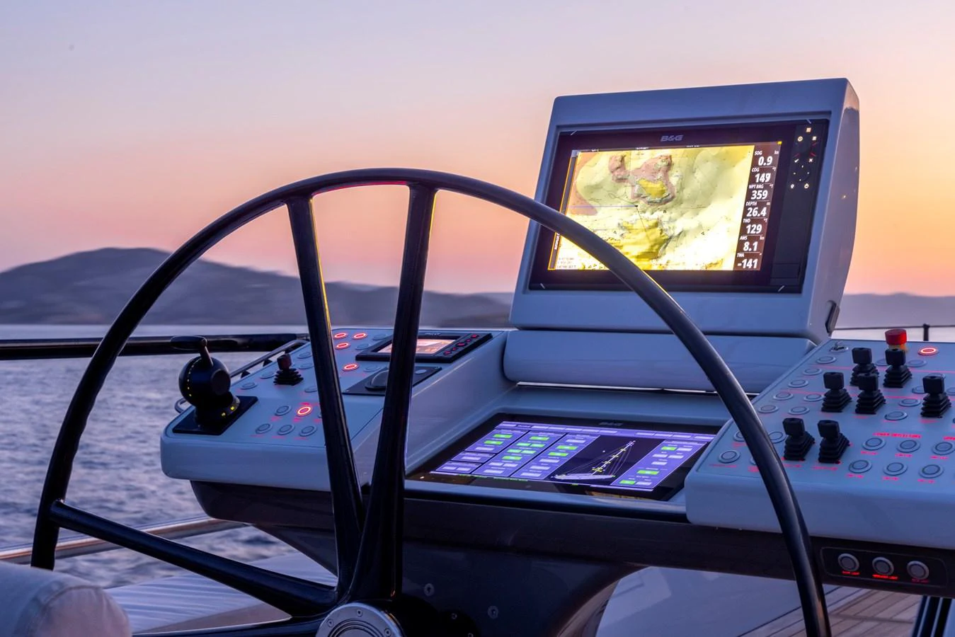 The helm station features advanced navigation equipment and a sleek steering wheel, set against a stunning sunset backdrop. aboard CANOVA Yacht for Sale