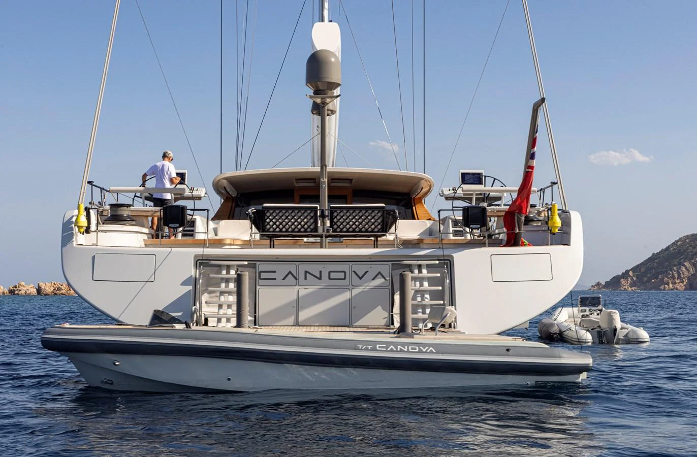 The yacht's aft deck is showcased with a tender attached, set against a serene ocean backdrop. aboard CANOVA Yacht for Sale