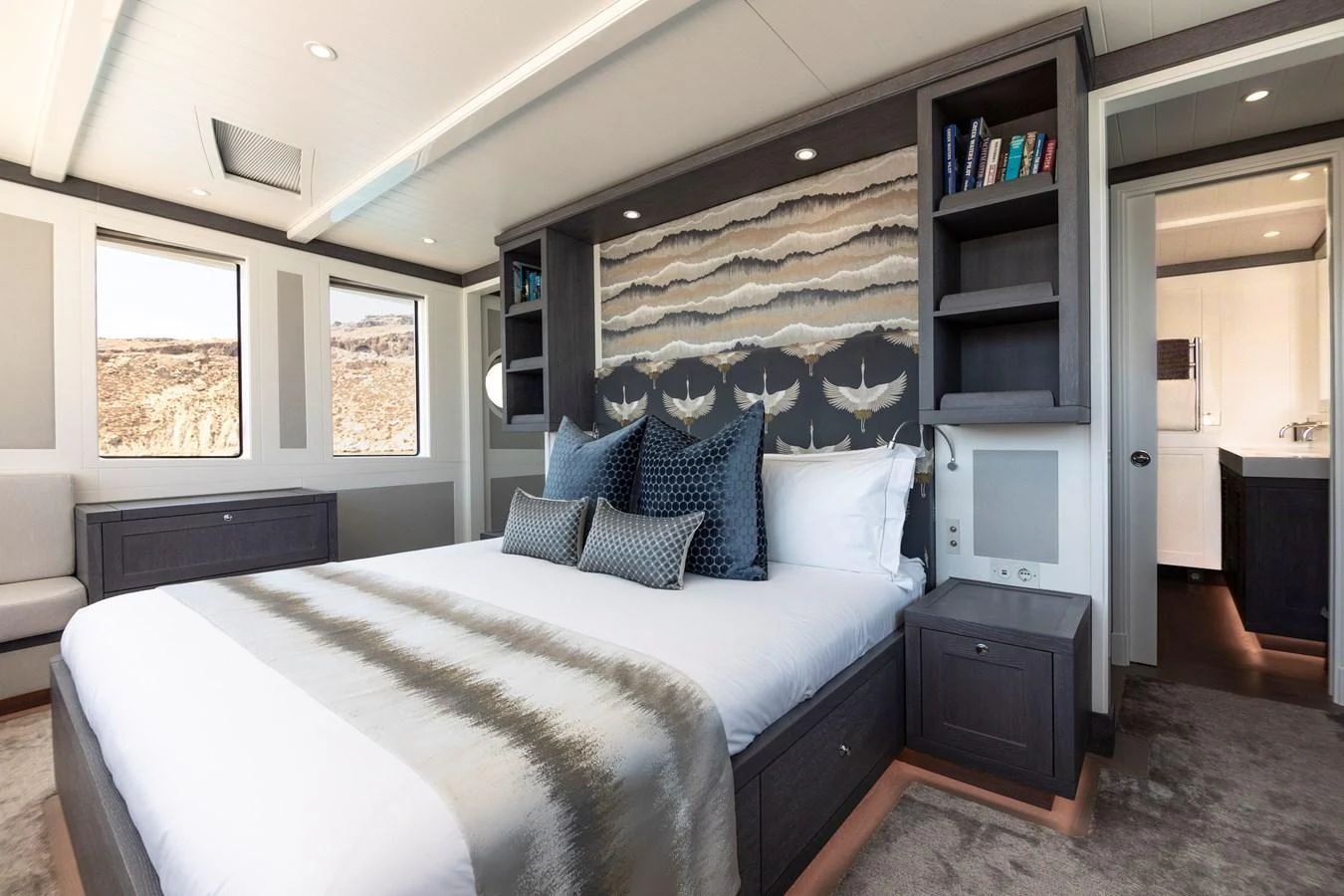 a bedroom with a bed and a bookcase aboard FAR NIENTE Yacht for Sale