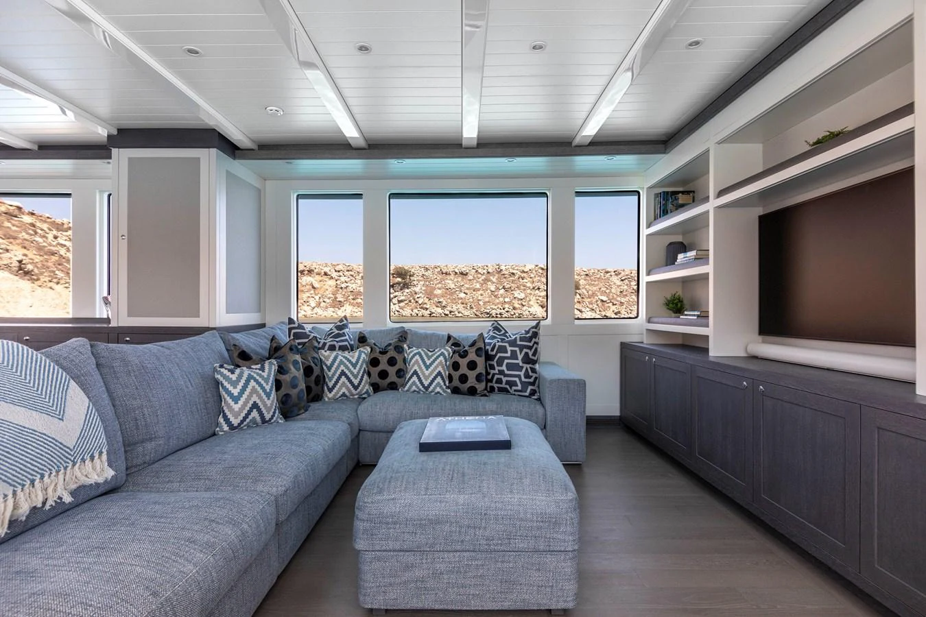 a living room with a blue couch aboard FAR NIENTE Yacht for Sale