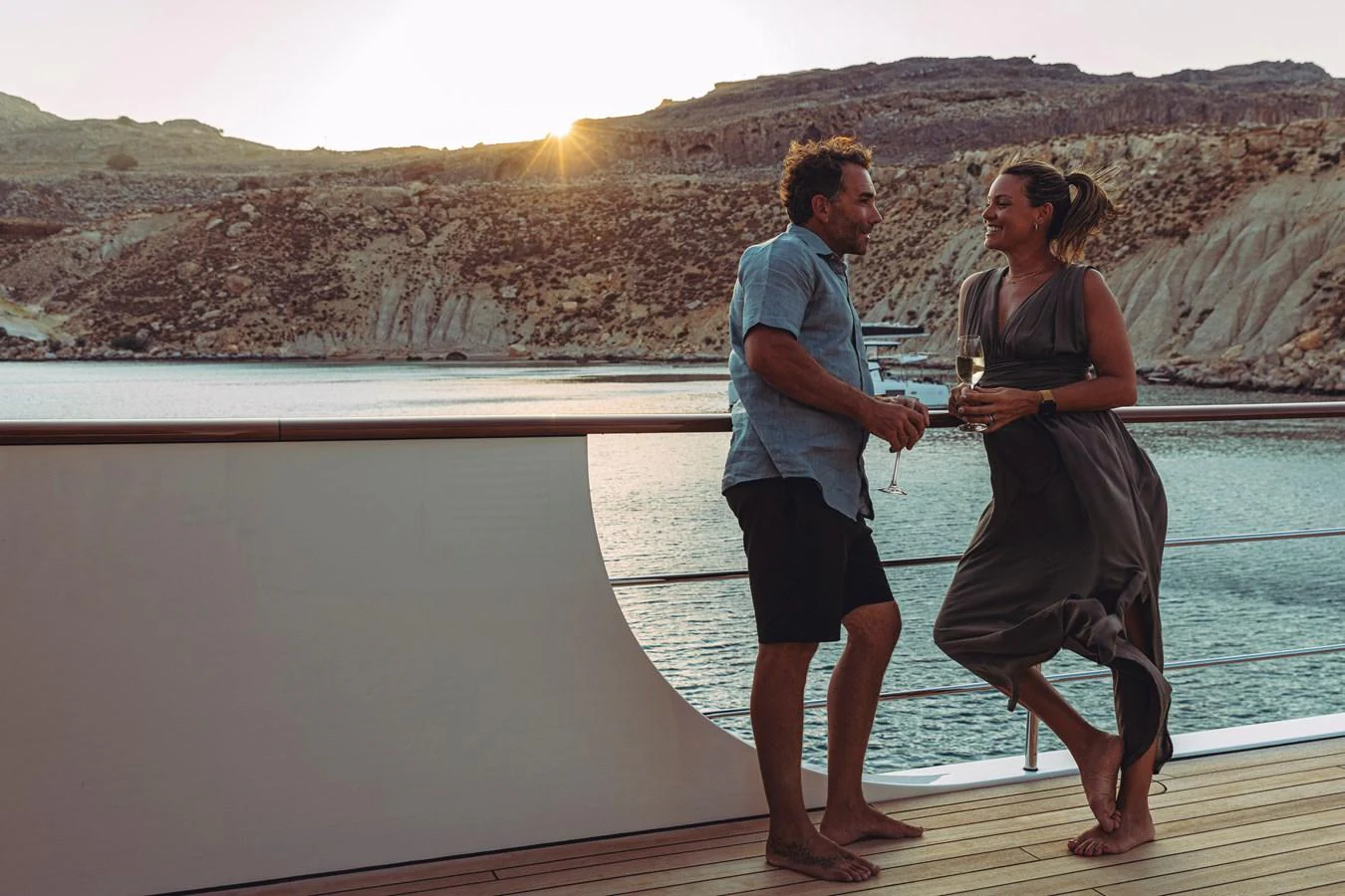 a man and woman holding a glass of wine on a dock aboard FAR NIENTE Yacht for Sale