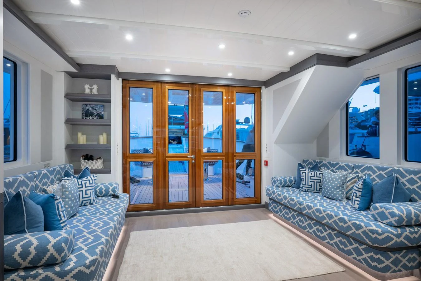 a living room with a blue couch and a large glass door aboard FAR NIENTE Yacht for Sale