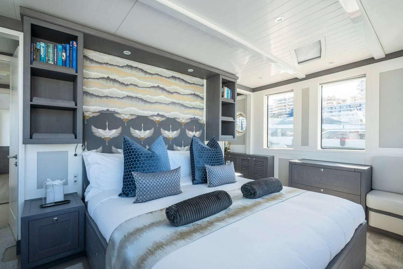 a bedroom with a bed and a bookcase aboard FAR NIENTE Yacht for Sale