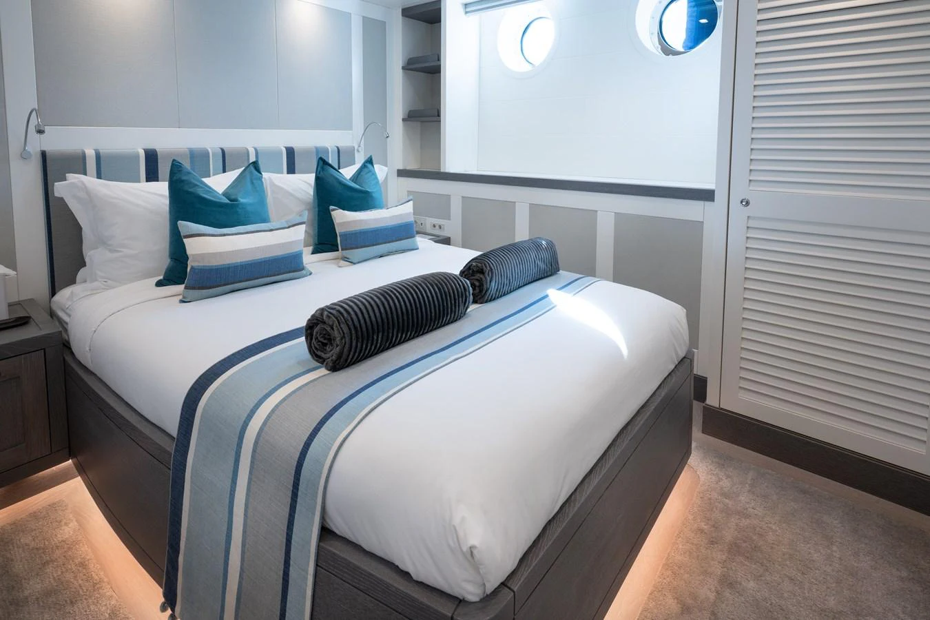 a bed with blue and white pillows aboard FAR NIENTE Yacht for Sale