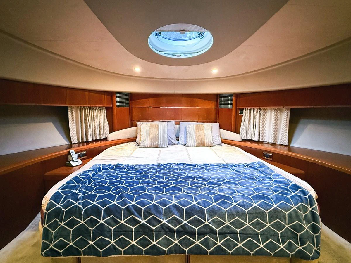 a bed with a blue comforter aboard ANDREA'S REVENGE Yacht for Sale