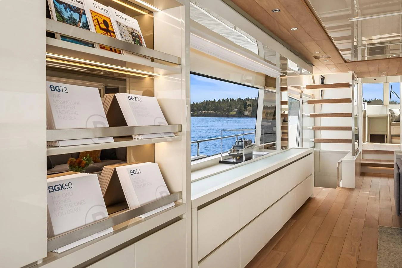 The yacht's interior features a modern and sleek design with ample natural light and stylish shelving. aboard ESSENZA Yacht for Sale