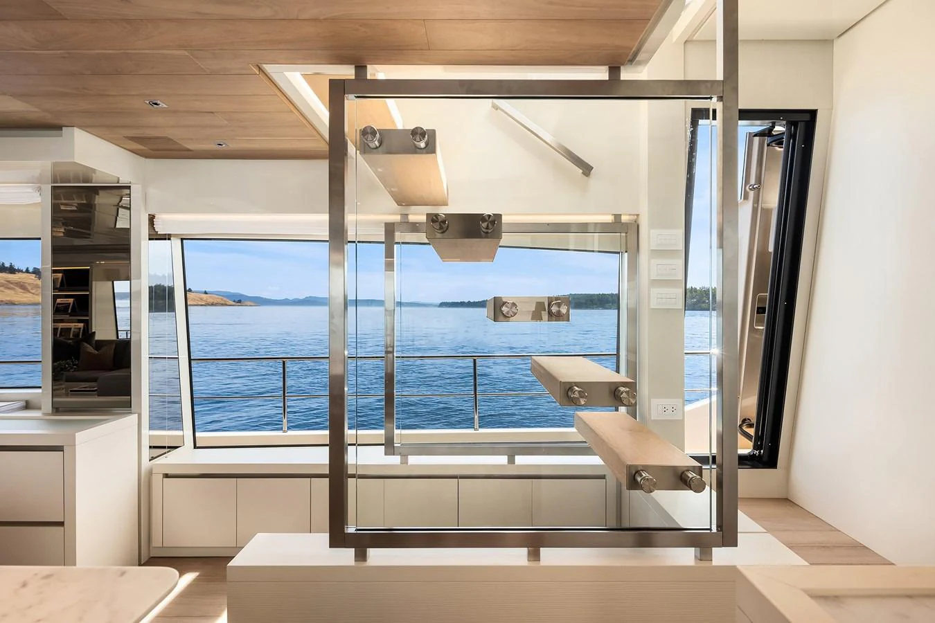 A modern interior staircase with a view of the sea through large windows. aboard ESSENZA Yacht for Sale