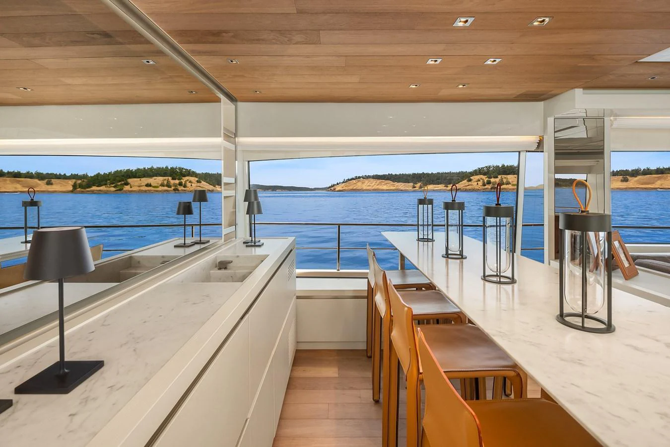 The yacht's dining area offers a stunning view of the water through large windows, complemented by modern furnishings and elegant decor. aboard ESSENZA Yacht for Sale