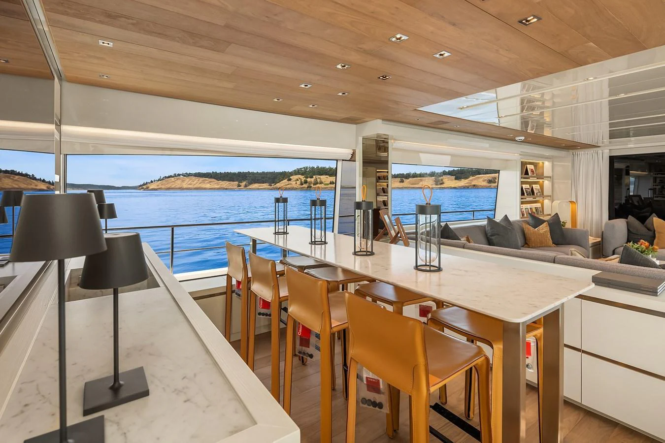The salon features a spacious dining area with a stunning view of the water through large windows. aboard ESSENZA Yacht for Sale