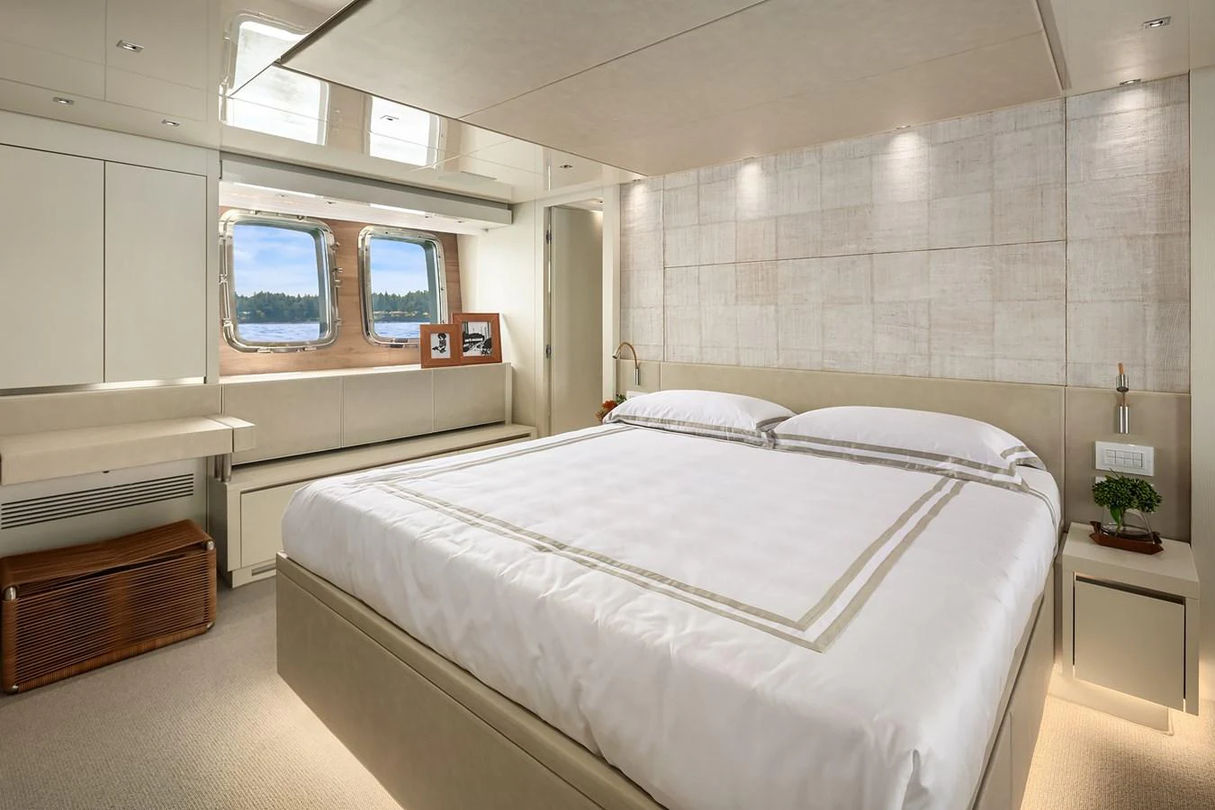 The stateroom features a luxurious bed with elegant linens and ample natural light from the windows. aboard ESSENZA Yacht for Sale