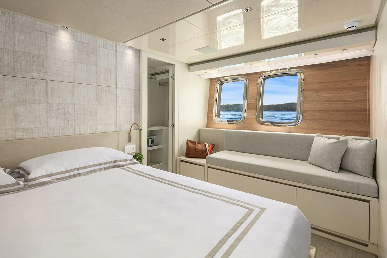 A serene stateroom with a large bed, cozy seating area, and ocean views through the windows. aboard ESSENZA Yacht for Sale