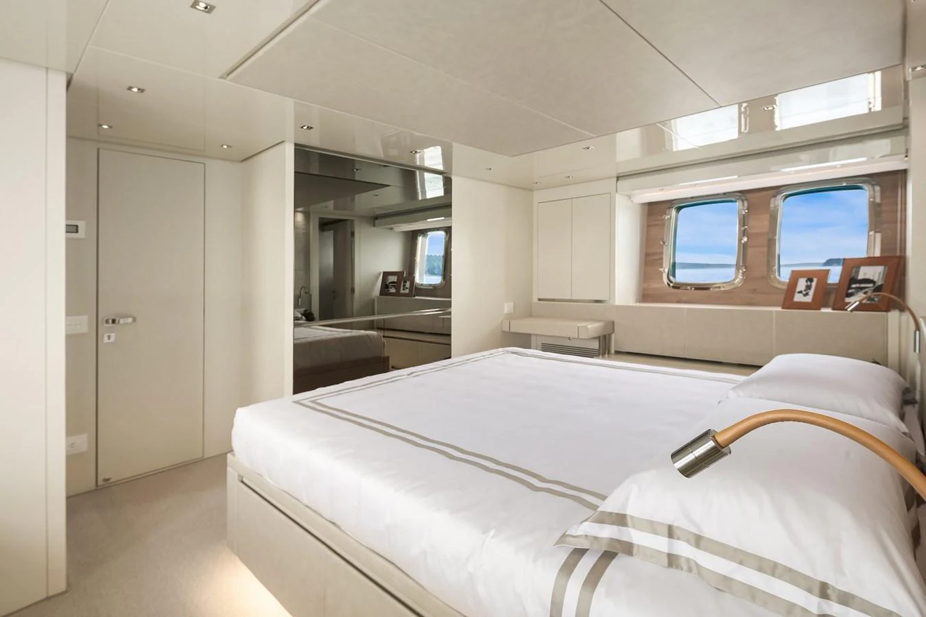 A luxurious stateroom featuring a large bed, ample natural light, and elegant decor. aboard ESSENZA Yacht for Sale