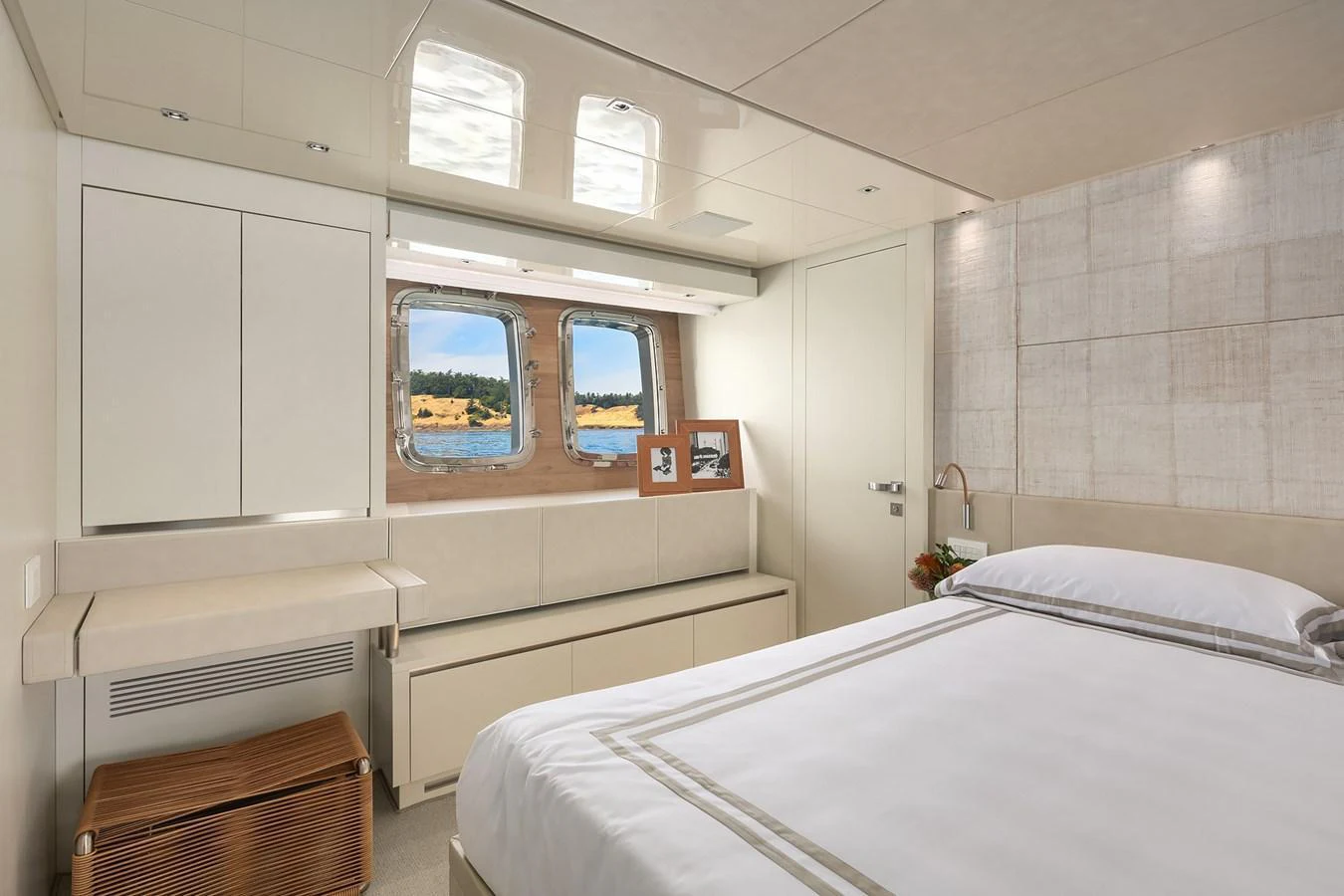 A serene guest stateroom featuring a large bed, ample storage, and a window with a picturesque view. aboard ESSENZA Yacht for Sale