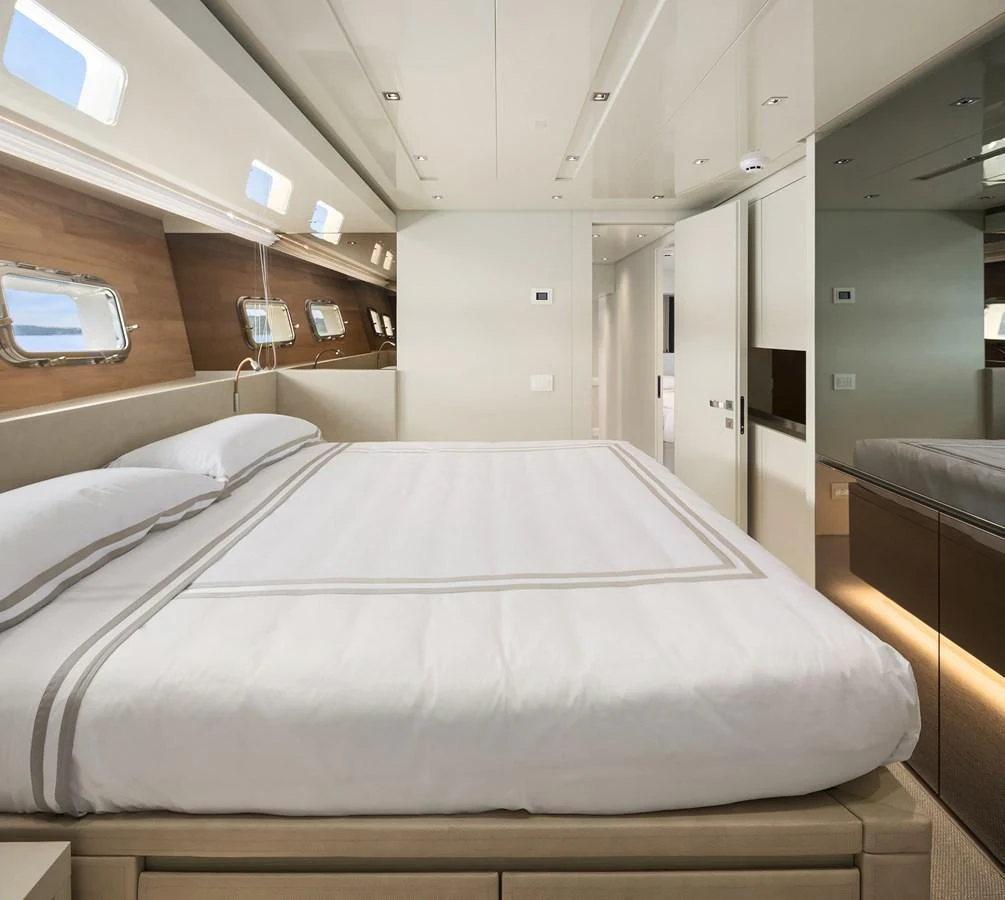 The master stateroom features a luxurious bed with elegant linens and ample natural light from the windows. aboard ESSENZA Yacht for Sale