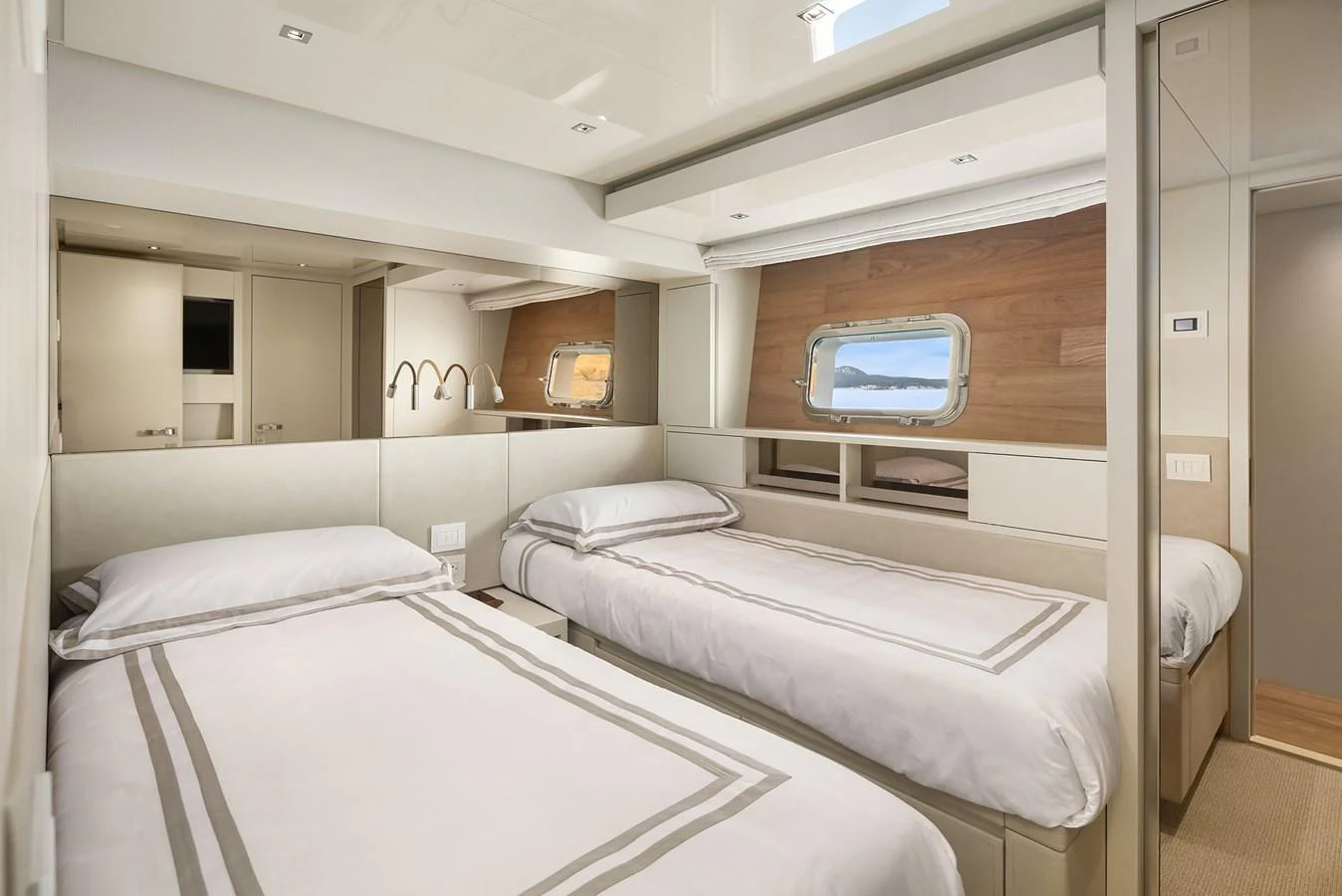 The guest stateroom features twin beds with elegant bedding and a serene view through the porthole. aboard ESSENZA Yacht for Sale