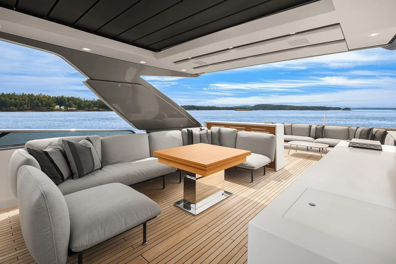 The aft deck features a spacious seating area with plush cushions and a central table, perfect for relaxation and socializing while enjoying the scenic views. aboard ESSENZA Yacht for Sale